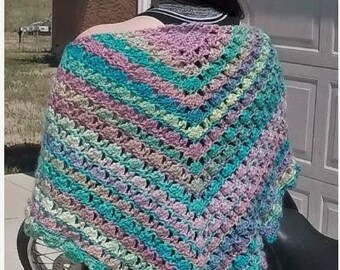 May include: A multi-colored crochet shawl with a scalloped edge. The shawl is made with a variety of shades of blue, green, and pink yarn.