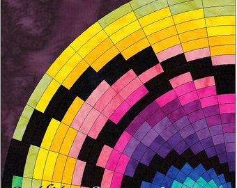 Puede incluir: Un bloque de colcha colorido con un diseño circular que presenta una variedad de colores, incluyendo verde, amarillo, rosa, morado y azul. El bloque está formado por pequeños cuadrados y rectángulos, y los colores están dispuestos en un patrón radial. El texto "quiltingSupport.com" es visible en la esquina inferior derecha del bloque.