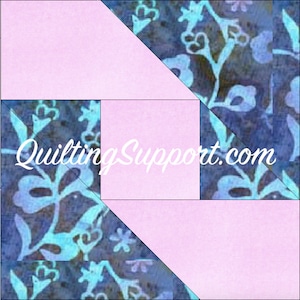 Puede incluir: Un bloque de acolchado con un tejido floral rosa y azul. El bloque está formado por cuatro cuadrados y cuatro triángulos. El texto "quiltingSupport.com" está en el centro del bloque.