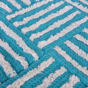 May include: A turquoise and white striped throw pillow with a textured, fluffy surface.