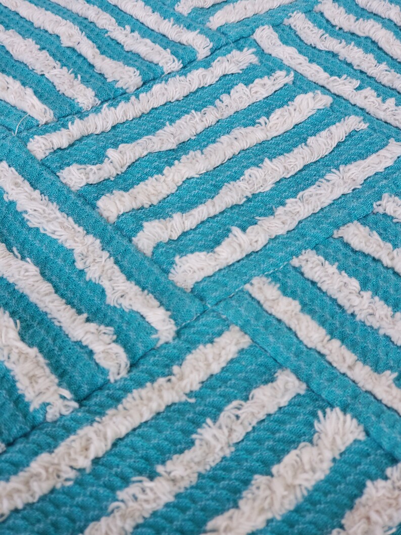 May include: A turquoise and white striped throw pillow with a textured, fluffy surface.
