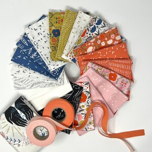 May include: A collection of fabric squares in various patterns and colors, including floral, geometric, and abstract designs. The fabrics are arranged in a circle with a roll of pink and orange ribbon in the center. The fabric squares are in shades of blue, pink, orange, yellow, and white. The fabric squares are all approximately 10 inches by 10 inches.