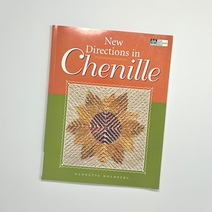 Puede incluir: Portada de libro con fondo verde y naranja. El título es "New Directions in Chenille" con un diseño de girasol en la portada. La autora es Nannette Holmberg.
