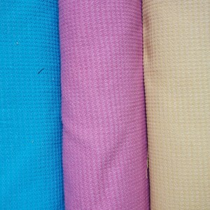 May include: Three rolls of fabric in different colors: blue, pink, and yellow. The fabric has a waffle texture.