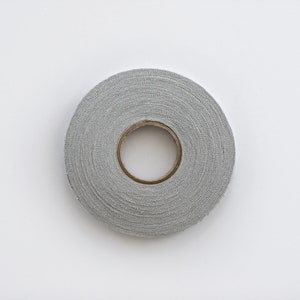 May include: A roll of gray fabric tape with a brown cardboard core.