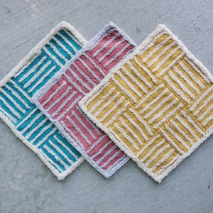 May include: Three bath mats in a woven pattern. The mats are teal, pink, and yellow.