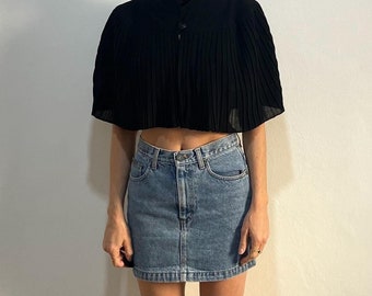 May include: A black cropped top with a high neck and a pleated design, paired with a light blue denim mini skirt.