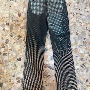 Puede incluir: Vaqueros de rayas blancas y negras con un patr&oacute;n de pata de gallo azul y blanco en los bolsillos traseros.