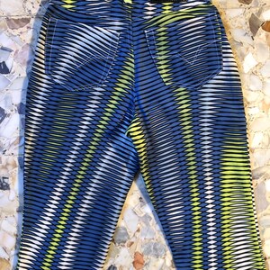 Puede incluir: Vaqueros con estampado azul, amarillo y blanco con una etiqueta negra de Versace Jeans Couture en la parte posterior.
