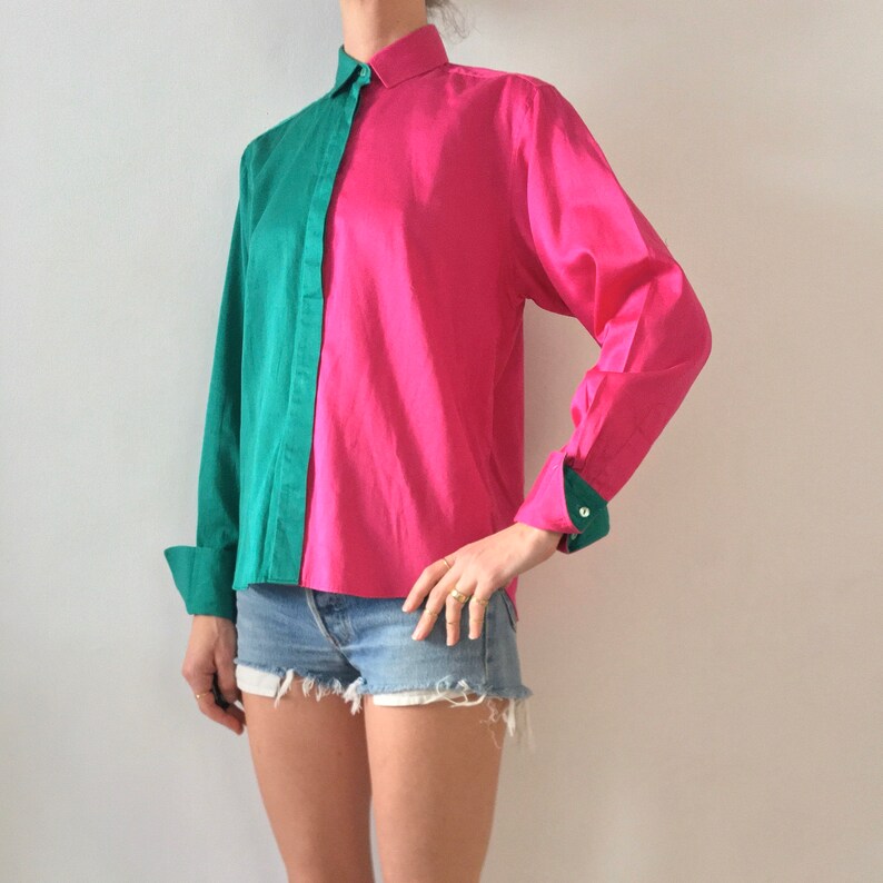 Puede incluir: Una camisa de manga larga con botones y un dise&ntilde;o de color contrastante. Una mitad de la camisa es verde y la otra mitad es rosa.