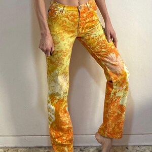 May include: A pair of yellow and orange tie-dye jeans with a straight leg fit.