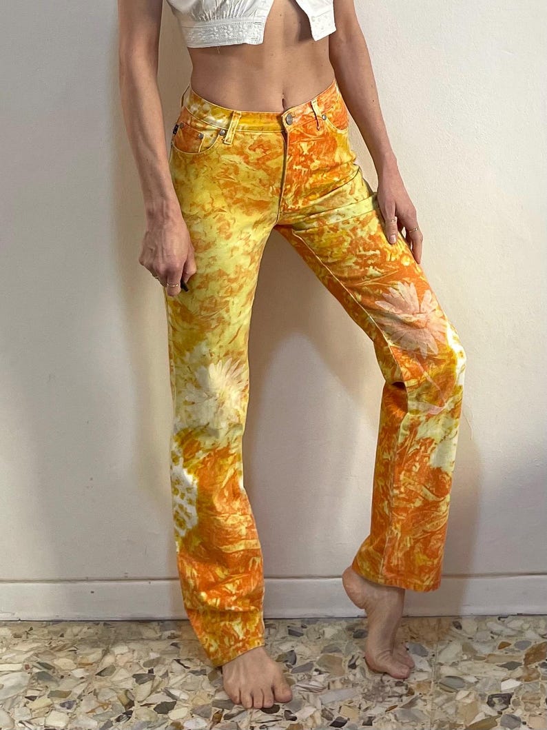May include: A pair of yellow and orange tie-dye jeans with a straight leg fit.