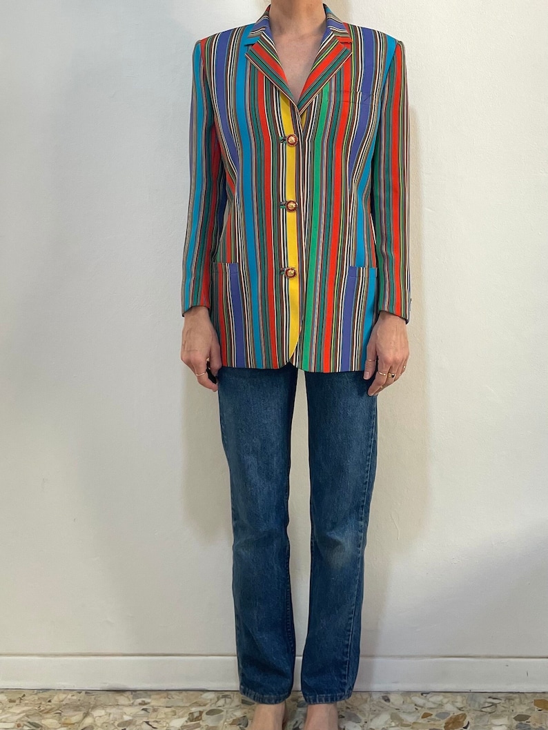 May include: A colorful striped blazer with a yellow button closure. The blazer is made of a lightweight fabric and has a relaxed fit.
