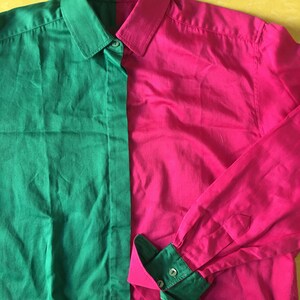Puede incluir: Una camisa de manga larga con botones y un dise&ntilde;o de bloques de color verde y rosa. La camisa tiene cuello y cierre de botones.
