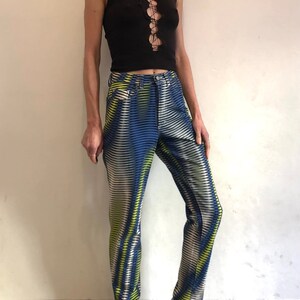 Puede incluir: Una camiseta negra sin mangas con un detalle de encaje en la parte delantera, combinada con pantalones de estampado azul y blanco.