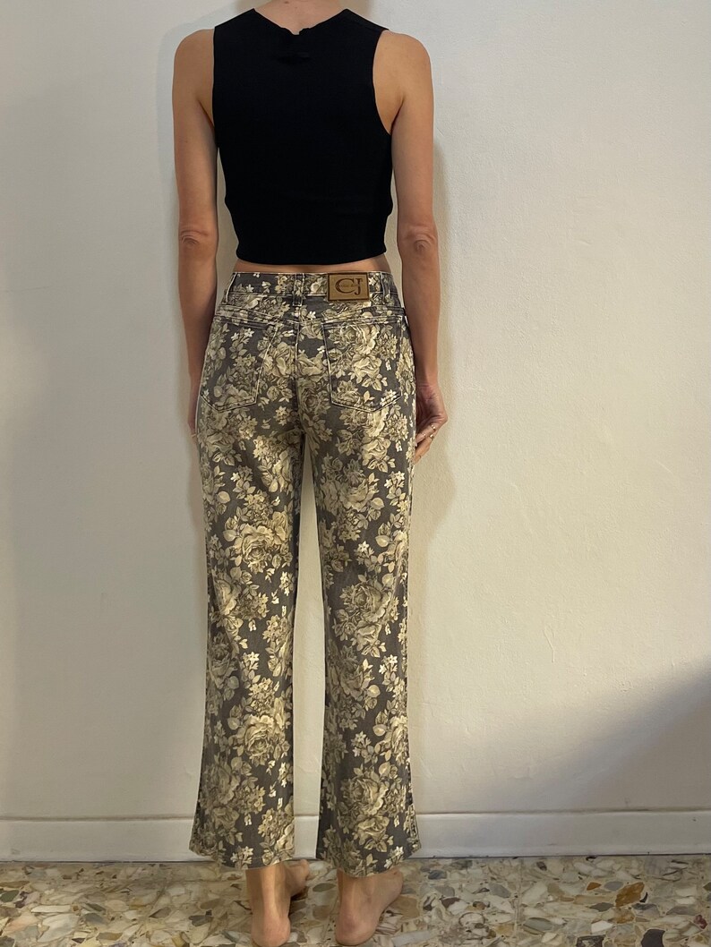 May include: A pair of brown floral print jeans with a brown leather patch on the back pocket that says "CJ".