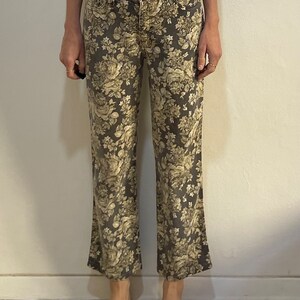 May include: A pair of wide-leg jeans with a floral print in shades of beige and brown.