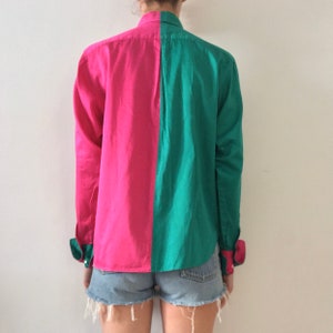 Puede incluir: Una camisa de manga larga con botones y un dise&ntilde;o de bloques de color rosa y verde. La camisa est&aacute; hecha de una tela de algod&oacute;n lisa.
