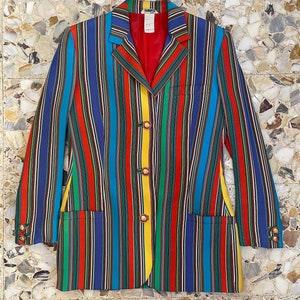 May include: A multi-colored striped blazer with a red lining and gold buttons. The blazer has a classic cut and is made of a lightweight fabric.