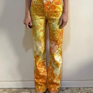 May include: A pair of yellow and orange tie-dye jeans with a straight leg fit.