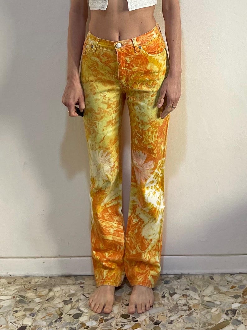 May include: A pair of yellow and orange tie-dye jeans with a straight leg fit.