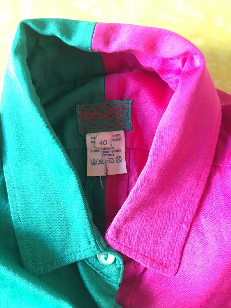 Puede incluir: Una camisa de cuello verde y rosa con una etiqueta de KENZO PARIS. La etiqueta tiene la talla 40 y el texto "100% Coton Baumwolle Cotone".