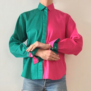 Puede incluir: Una camisa de manga larga con botones y un dise&ntilde;o de color contrastante. Una mitad de la camisa es verde azulado y la otra mitad es rosa intenso.