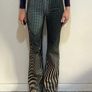 Puede incluir: Un par de pantalones vaqueros de pierna ancha con estampado negro y verde.