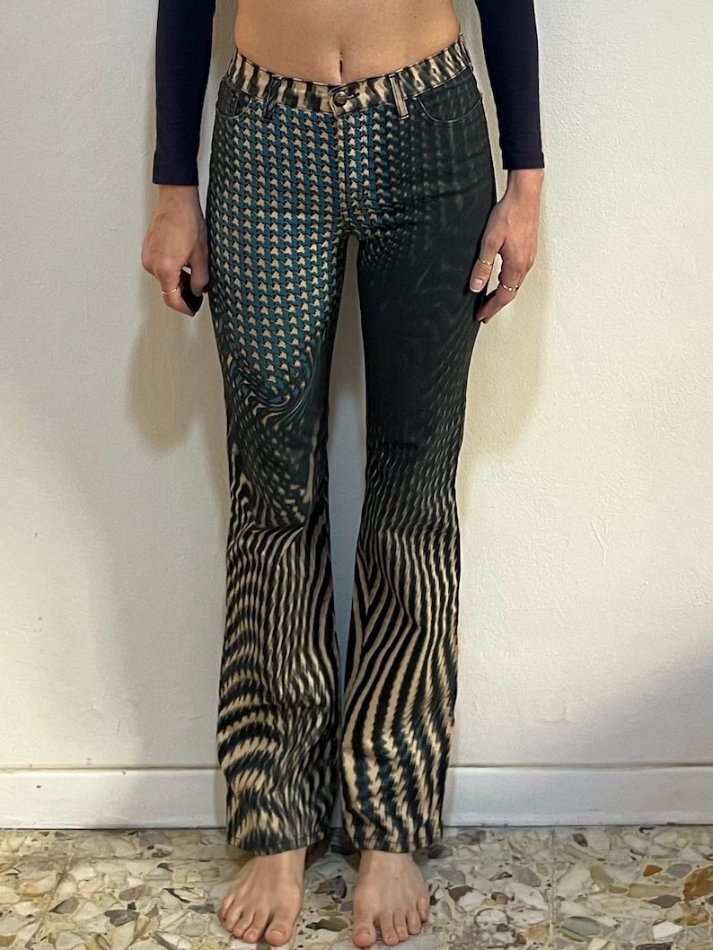 Puede incluir: Un par de pantalones vaqueros de pierna ancha con estampado negro y verde.