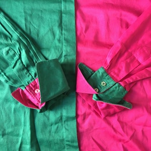 Puede incluir: Una camisa de manga larga con un dise&ntilde;o de bloques de color verde y rosa. La camisa tiene un cuello abotonado y pu&ntilde;os abotonados.