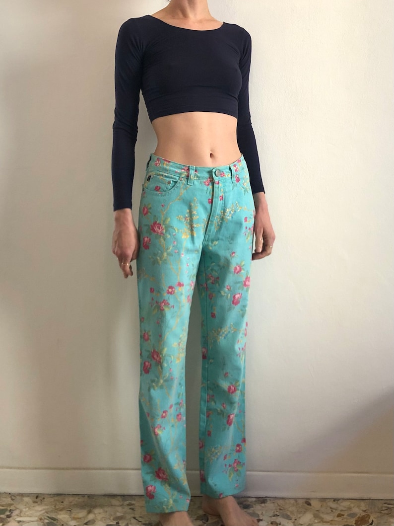 May include: A pair of light blue jeans with a floral print. The jeans have a straight leg and a high waist.