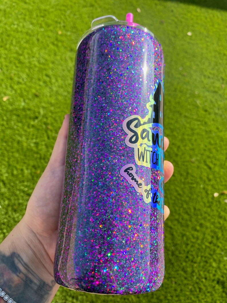 Puede incluir: Un vaso de glitter negro y morado con una pegatina que dice "Save the Witch" y "Home of the"