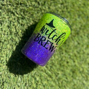 May include: A green and purple glitter tumbler with the text "witch's brew" and a black witch's hat graphic.
