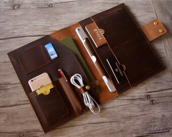 May include: Brown leather portfolio with multiple pockets and compartments for carrying a tablet, phone, pens, and other items. The portfolio has a flap closure with a snap button.