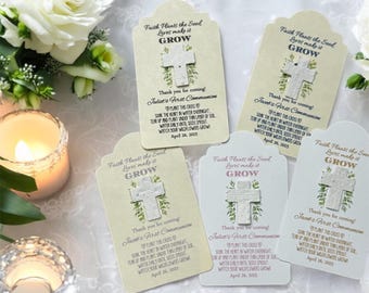 May include: Five white card favors with a cross design and the text "Faith Plants the Seed Love Makes it Grow" and "Thank you for coming! [Name]'s First Communion" with a date. The cards are decorated with green leaves and a white cross.