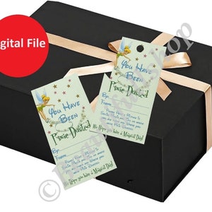 Puede incluir: Dos etiquetas de regalo imprimibles con Campanilla y el texto "You Have Been Pixie Dusted". Las etiquetas están sobre un fondo negro con una cinta dorada.