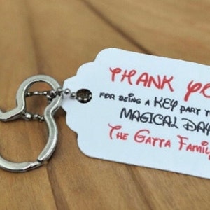 May include: A silver Mickey Mouse keychain with a white tag that says "Thank You for being a key part to our magical day The Gatta Family".