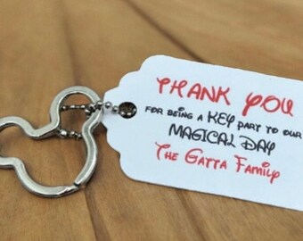 May include: A silver Mickey Mouse keychain with a white tag that says "Thank You for being a key part to our magical day The Gatta Family".