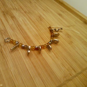 May include: A white ceramic mug with a black handle and the text "But First, Coffee" in a bold, black font. The mug is set against a blurred background, suggesting a cozy setting.