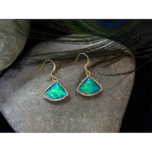 May include: A pair of gold dangle earrings with iridescent green teardrop-shaped stones set in silver.