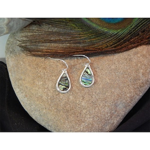 May include: A pair of teardrop-shaped earrings with iridescent abalone shell insets and silver-colored metal frames. The earrings hang from curved ear wires. The abalone shells display a mix of green, blue, and purple hues.