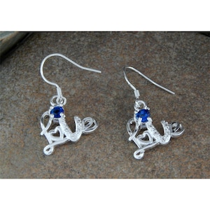 May include: Silver earrings with a blue gemstone in the center of the word "love" in a cursive font.
