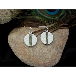 May include: A pair of silver earrings with a round, hammered metal design. Each earring features a green and brown abalone shell inlay.