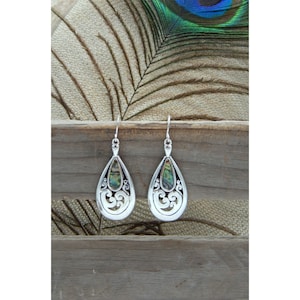 May include: A pair of silver teardrop earrings with a delicate filigree design and iridescent abalone shell accents.