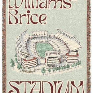Könnte beinhalten: Eine gewebte Wohndecke mit hellgrünem Hintergrund und einer detaillierten Abbildung des Williams-Brice Stadions in der Mitte. Der Text Williams-Brice ist in Dunkelrot über dem Stadion gedruckt, das Wort STADIUM steht darunter.