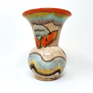 以下が含まれることがあります： 広がった開口部と丸みを帯びたボディを持つ、小さなセラミック製の壺。壺は、青、オレンジ、黄色、茶色の色合いでカラフルな抽象的なデザインで装飾されています。