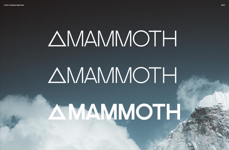May include: Three instances of the word "MAMMOTH" in a sans-serif font are displayed against a backdrop of a mountain and cloudy sky. The word is white, with a triangle replacing the letter "A". The image is a typeface specimen.