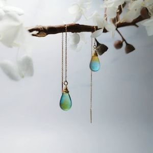 May include: A pair of gold chain earrings with teardrop-shaped blue and green glass beads.