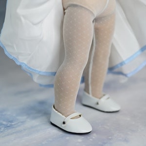 May include: White tights with a small polka dot pattern and white shoes with a black buckle.