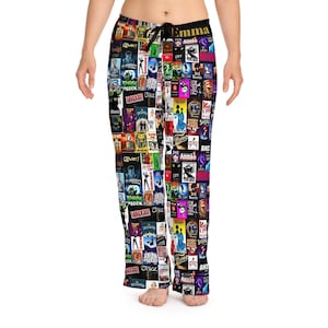 Puede incluir: Pantalón de pijama negro con un estampado colorido de carteles de espectáculos de Broadway. Los carteles incluyen títulos como "Wicked", "Chicago", "Annie", "Oliver!" y "Once".